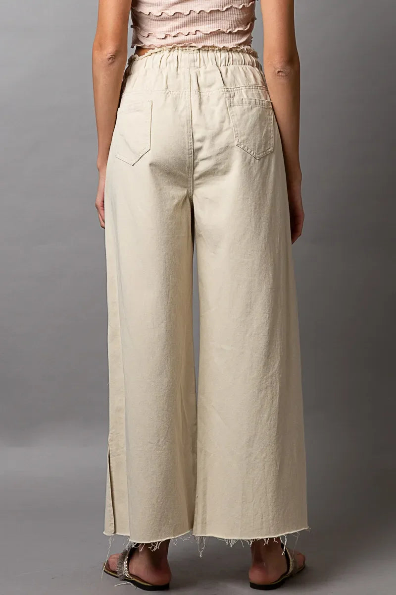 Cream wide-leg pants with frayed hem and side slits, back view