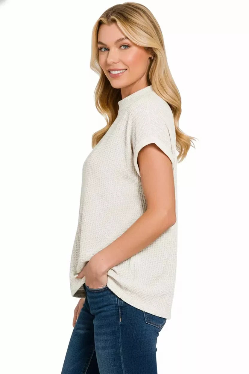 Cream waffle knit short sleeve top with relaxed fit, paired with blue jeans for a cozy, trendy look