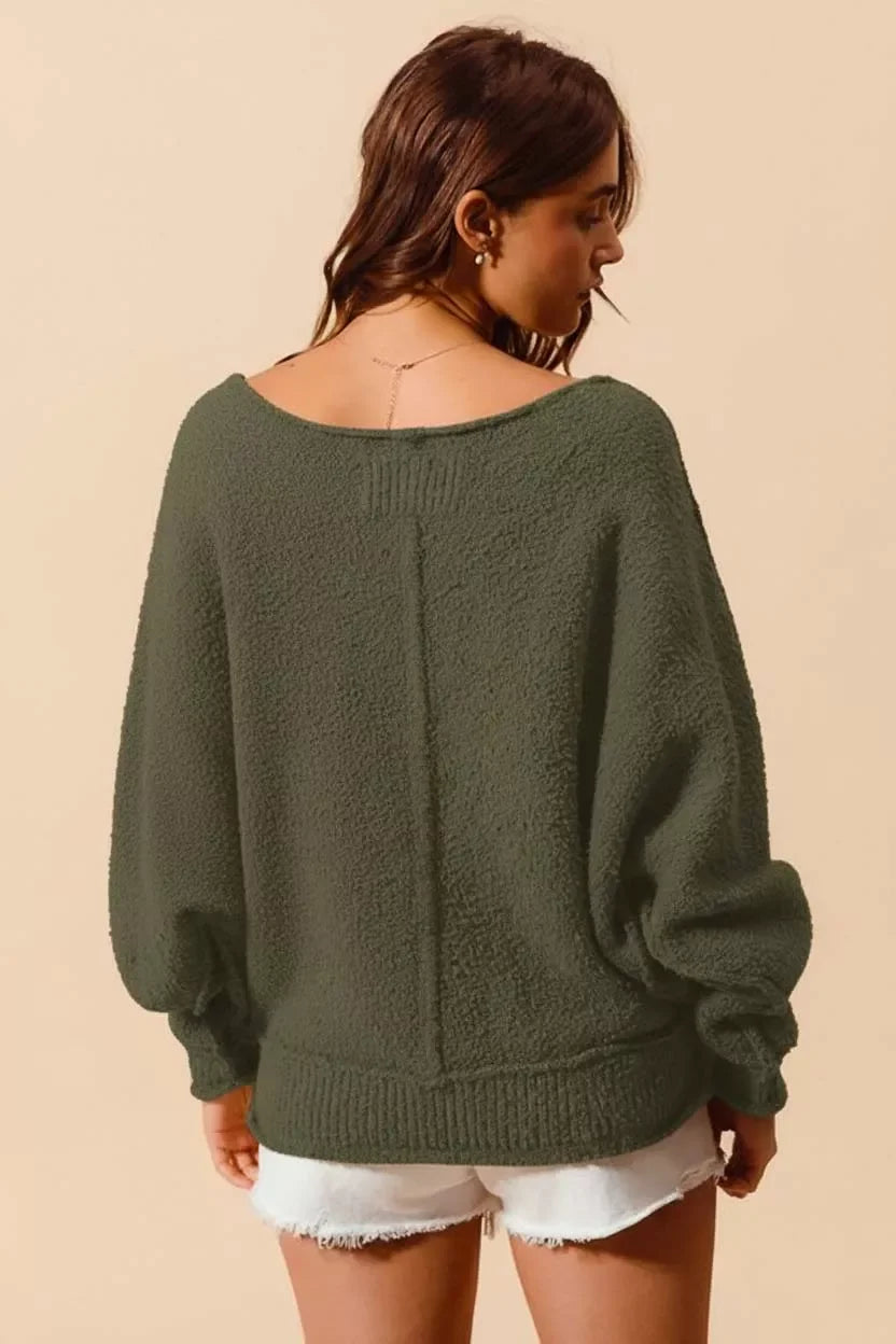 Olive green cozy sweater with wide sleeves and open back, paired with white denim shorts for a trendy look