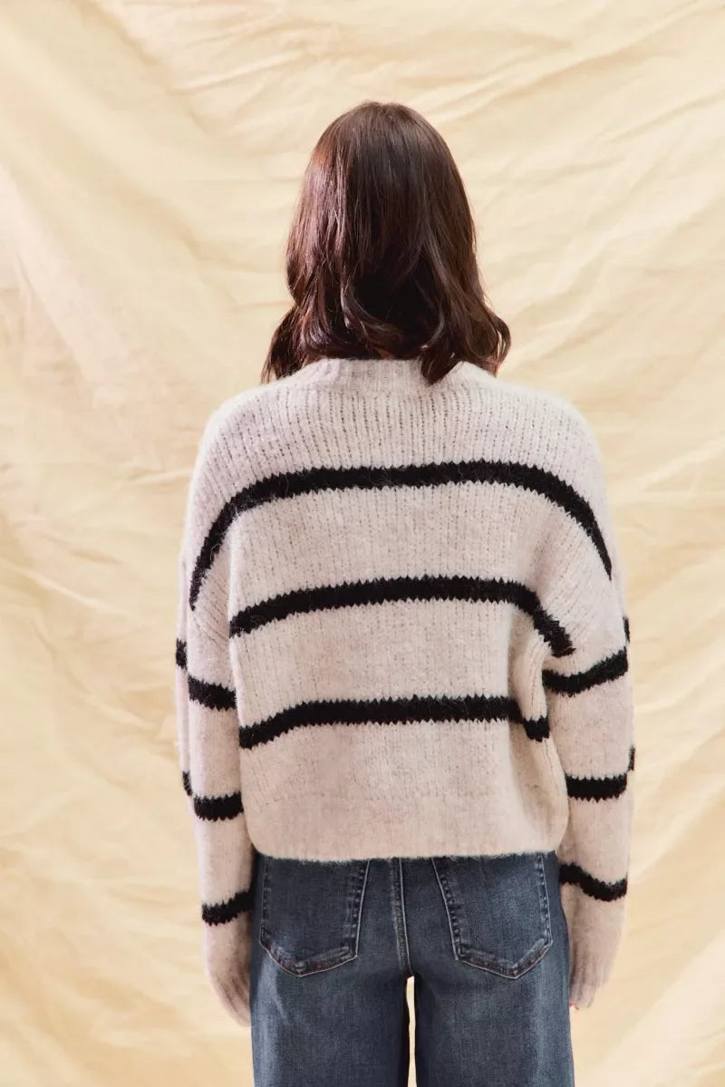 Cozy striped knit sweater with black horizontal stripes, back view, paired with jeans